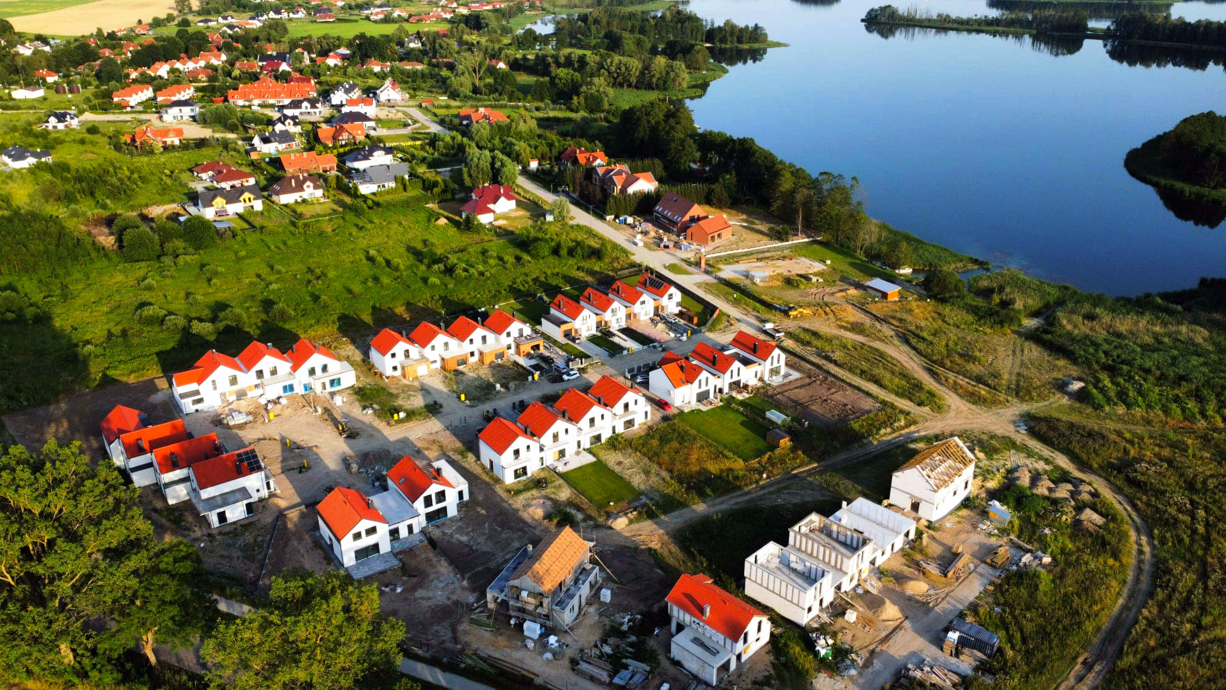 Panorama terenów zielonych i zabudowy jednorodzinnej w okolicy jeziora